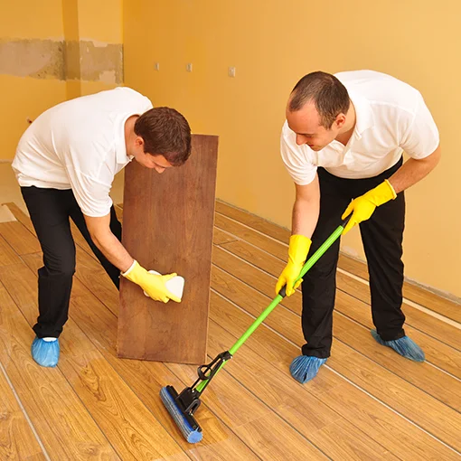 Cleaners wiping and mopping a wooden floor