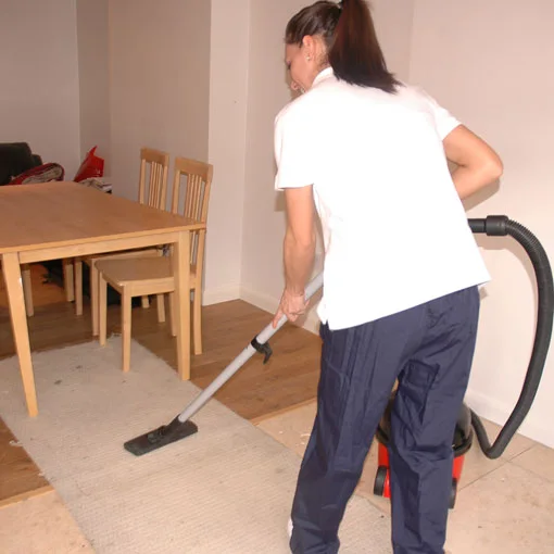 Vacuuming a floor beside a dining table