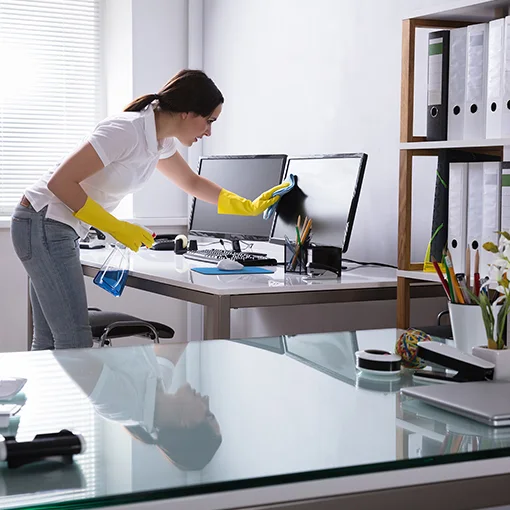 Wiping a desk beside a computer