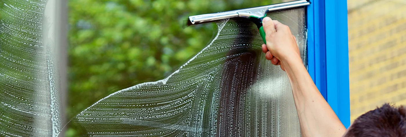 Squeegee drawing water from window glass