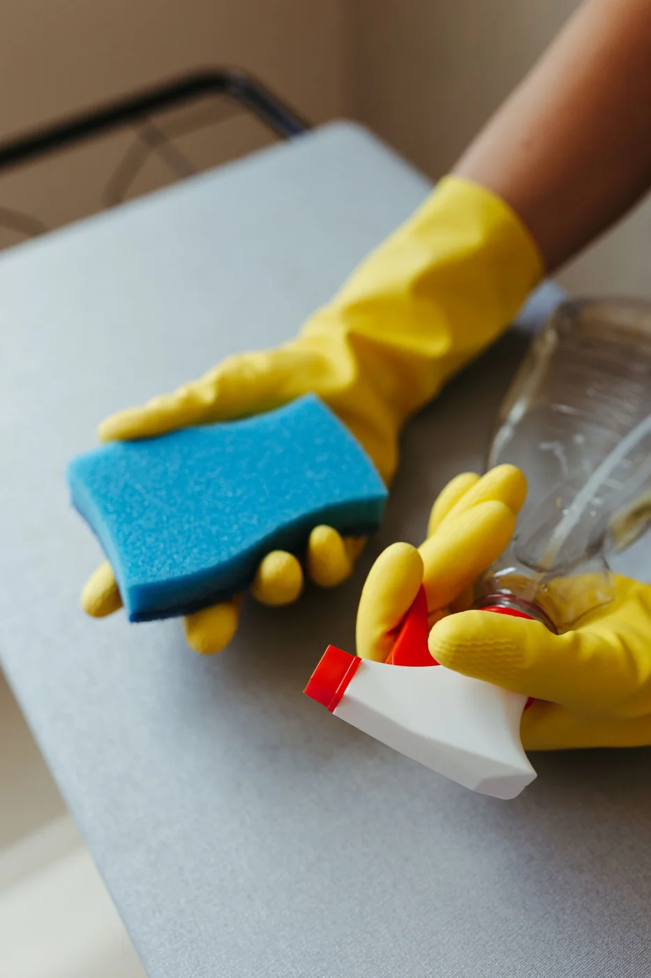 Gloved hand wiping a surface with a sponge