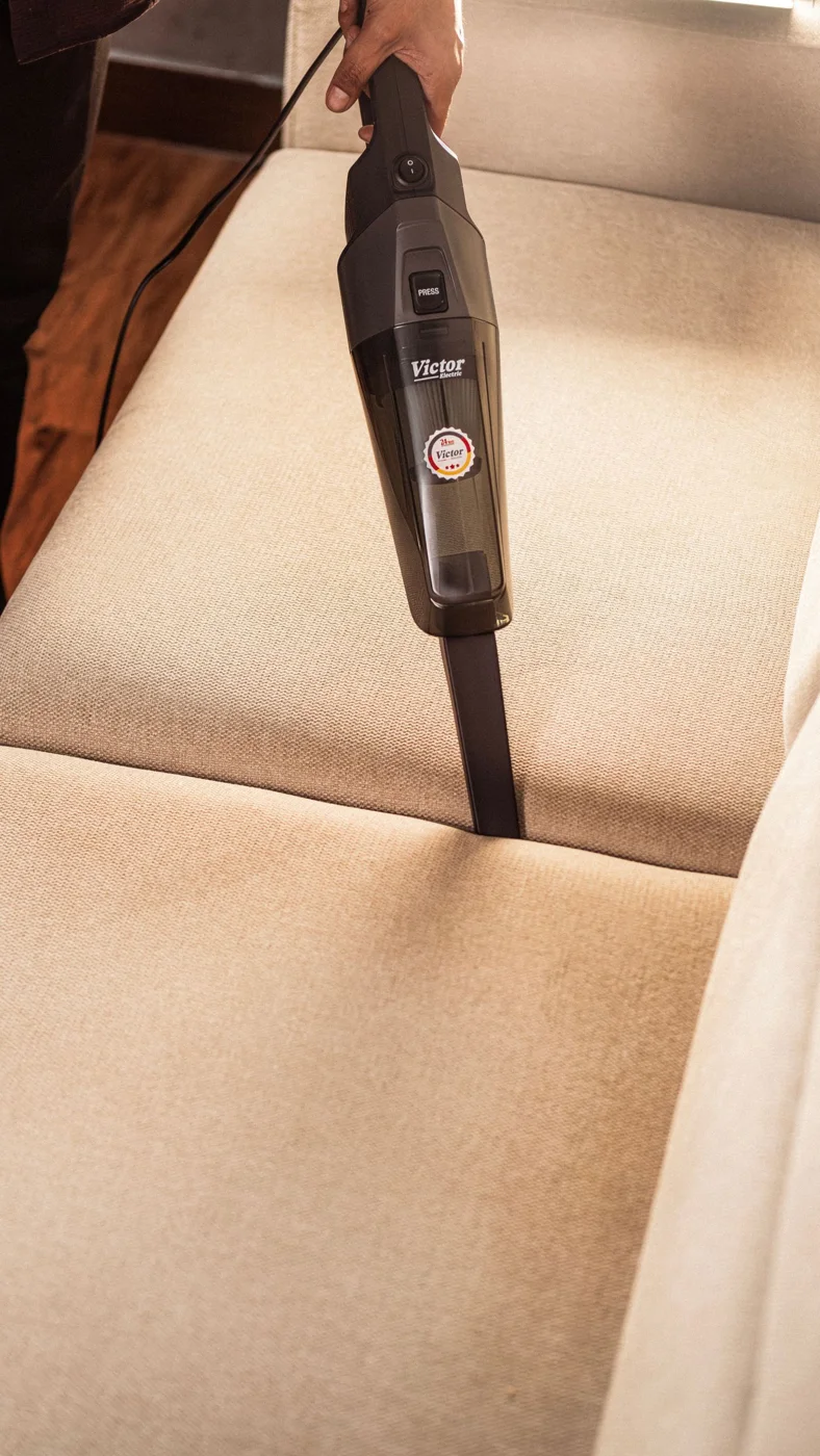 Vacuuming the seat of a fabric sofa