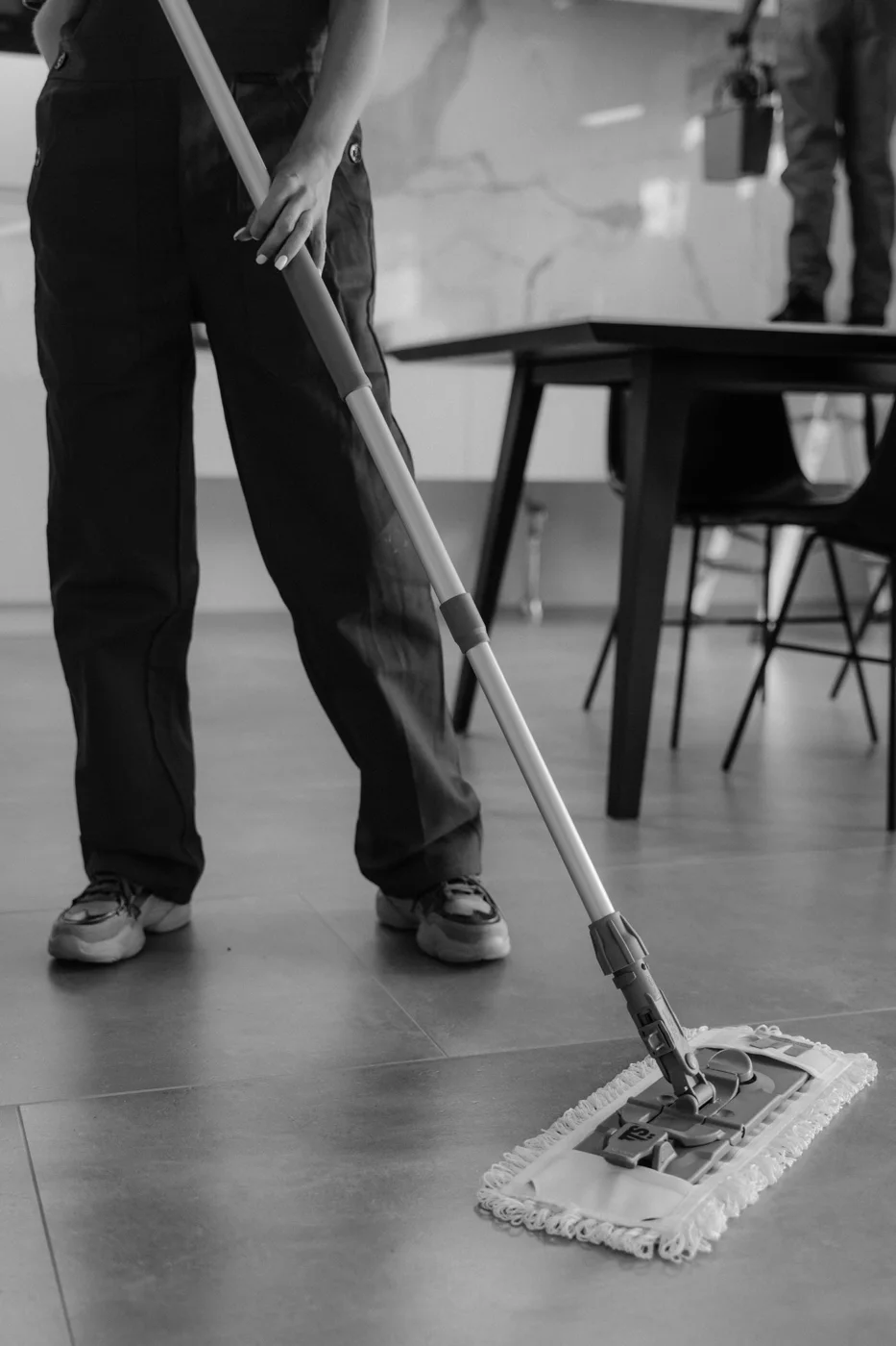 Cleaner mopping a tiled floor