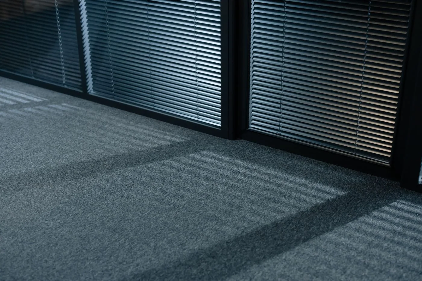 Window blinds above a carpeted office floor