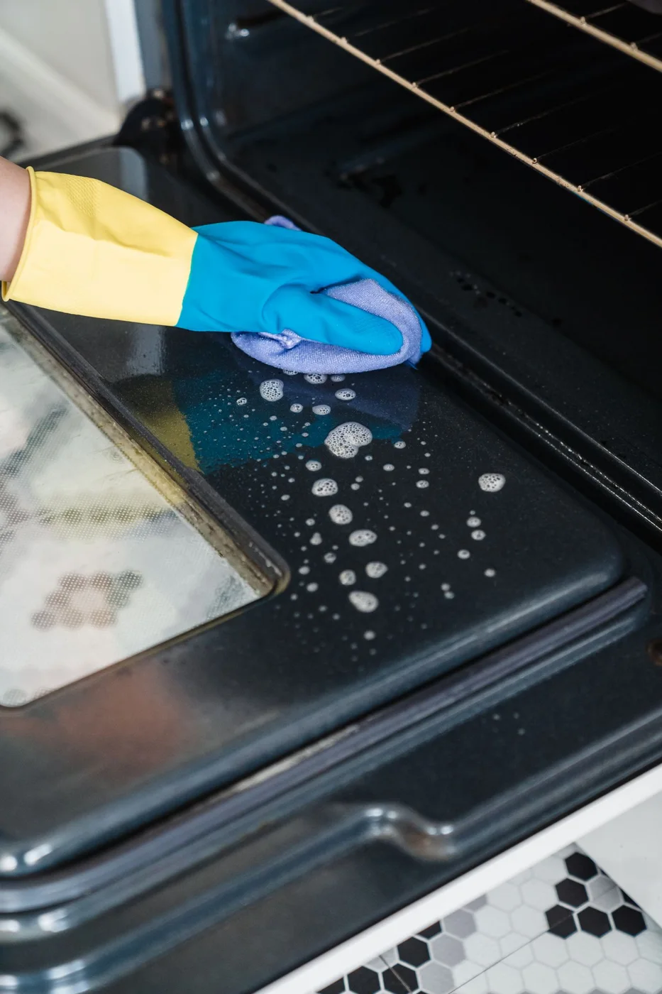 Cleaning the glass on an open oven door